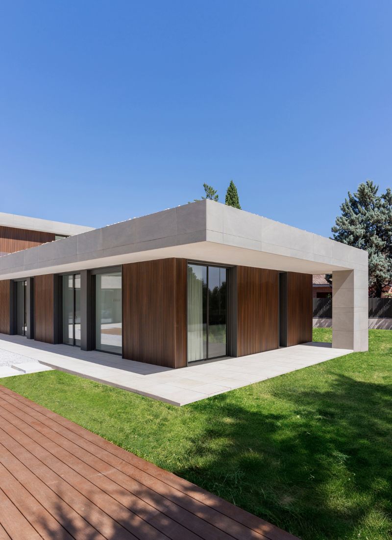 Veranda mit grauen Porzellanfliesen und technischem Holz in einem L-förmigen Haus in Madrid