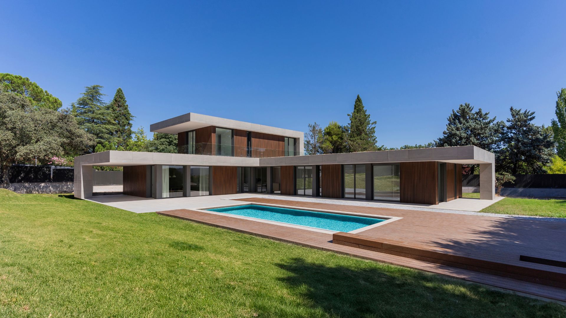 Fassade eines L-förmigen Hauses in Madrid mit technologischer Holzverkleidung.