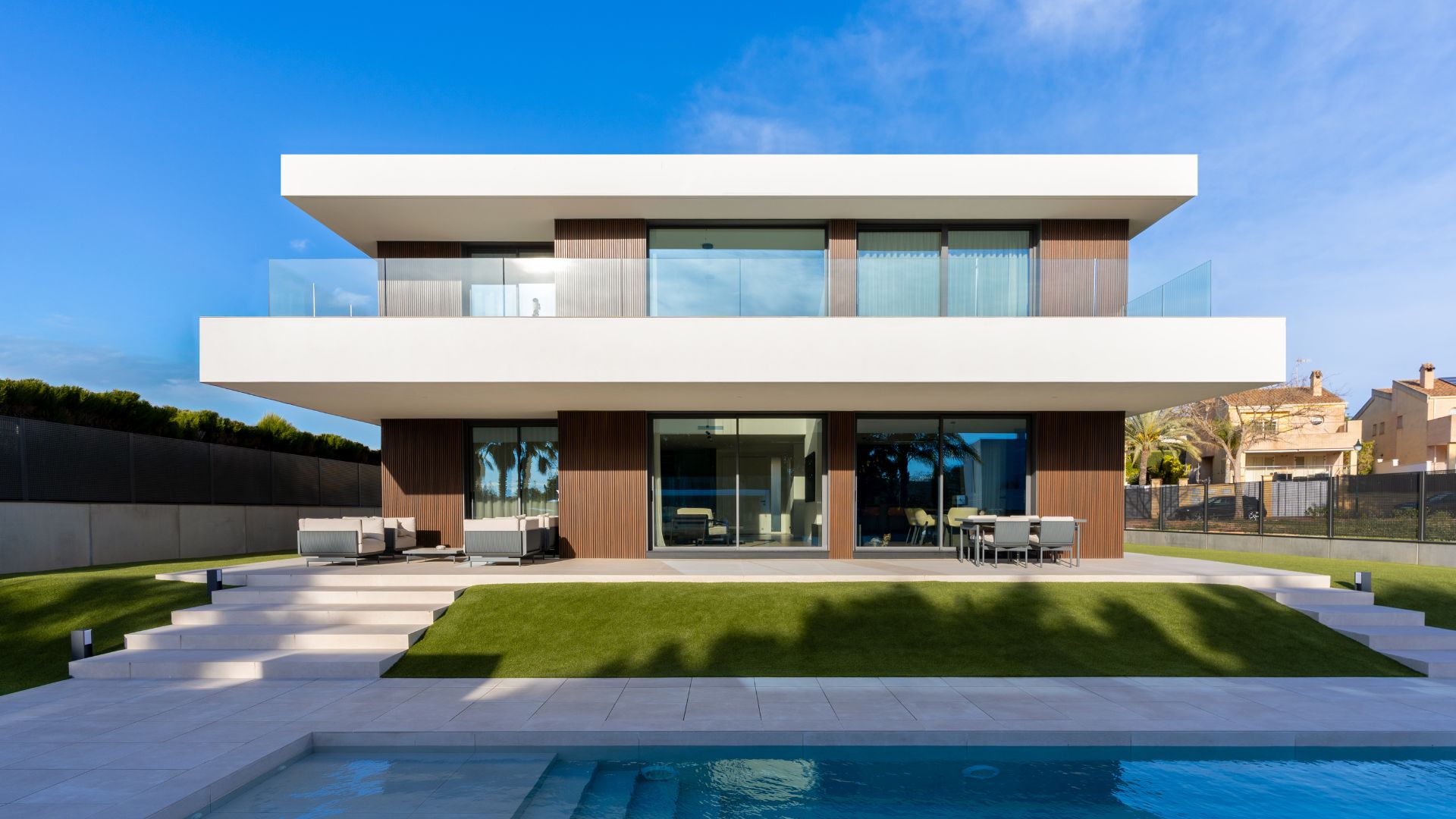Fassade mit technologischer Holzverkleidung und weißem Einschichtmörtel Vorderansicht eines luxuriösen Hauses im mediterranen Stil