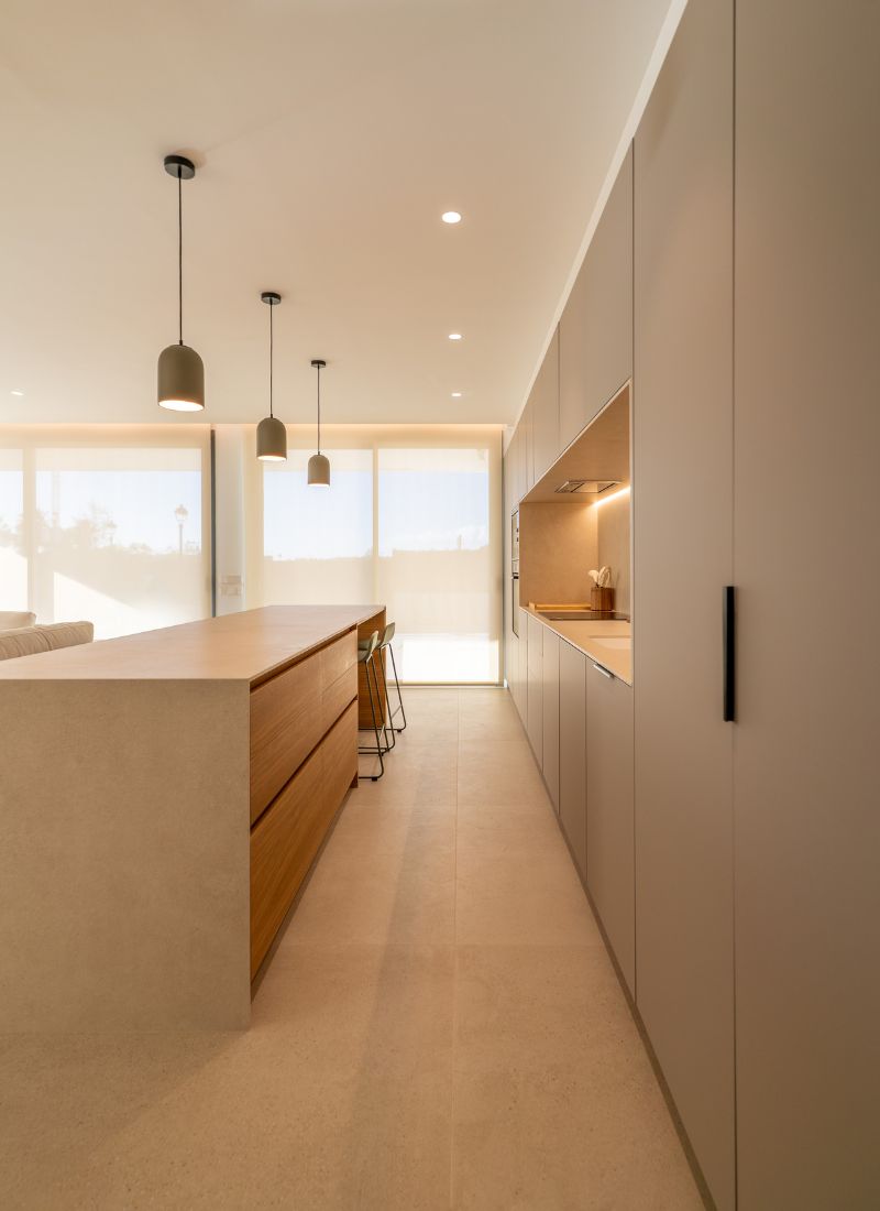 Beigefarbene Küche mit Kochinsel und kompakten Schränken